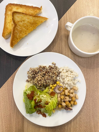 A toasted bread quinoa barley salad mixed beans cream soup lettuce corn healthy breakfast whole grain breakfast plate woodenの写真素材