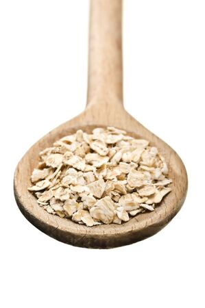 wooden spoon with porridge oats isolated on white backgroundの写真素材