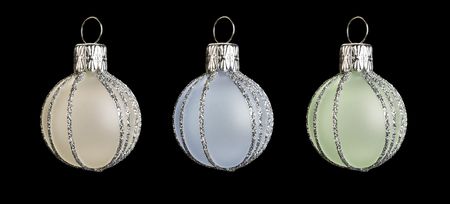 three colored christmas baubles on black backgroundの写真素材