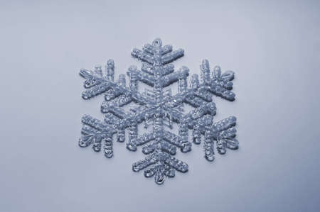 single plastic snowflake on light blue background の写真素材