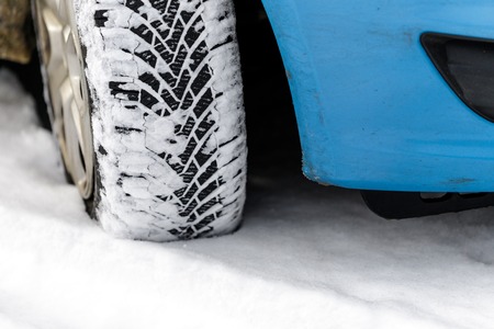 Car tyre in winter covered with snow.On road with fresh snow. close up.の写真素材