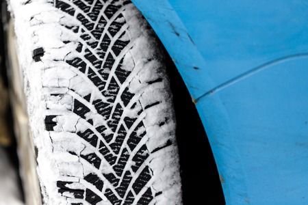Car tyre in winter covered with snow.On road with fresh snow. close up.の写真素材