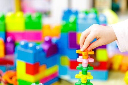Children plastic color bricks with children hand. close up.の写真素材