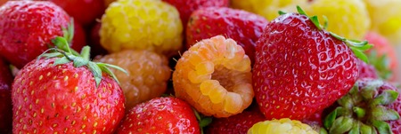 bio yellow raspberries with red strawberries. close up.の写真素材