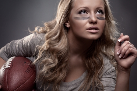 beautiful girl holding a ball for american footballの写真素材