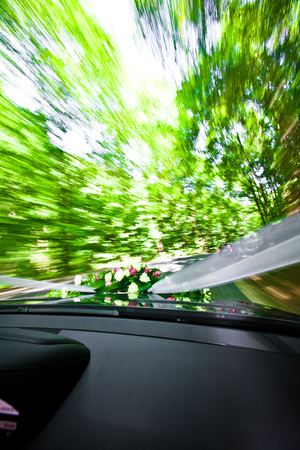 wedding Car is driving on a road direction railway crossing (level crossing). Shot from inside the car with motion blur.の写真素材