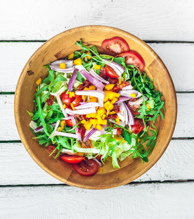 fresh colorful vegetable salad on a white wooden tableの写真素材