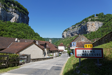 The village of Baume-les-Messieurs lies within the most extensive of the steephead valleys of the Jura escarpment, the "Reculee de Baume", limestone cliffs about 200m high.の写真素材
