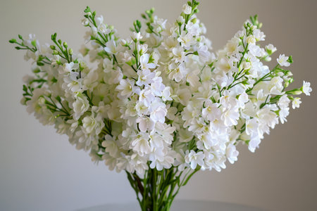 Elegant White Snapdragons Arranged in a Vase Against a Neutral Background for Interior Decor AI Generativeの素材