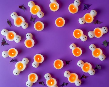 Vibrant Halloween Themed Background with Ghost Candies, Orange Pumpkins, and Bats on a Purple Surface AI Generativeの素材