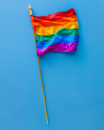 Vibrant Rainbow Pride Flag Against Light Blue Background Symbolizing LGBTQ Community and Equality AI Generativeの素材