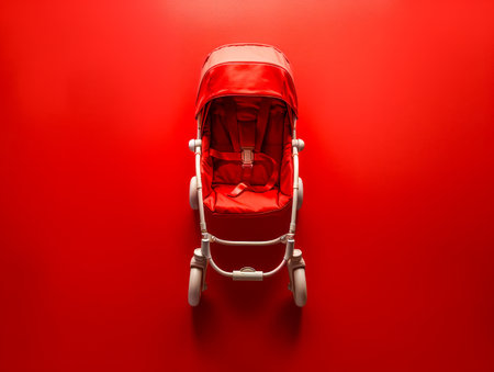 Bright Red Baby Stroller Against Vivid Red Background Vibrant Color, Modern Design, Infant Care, Child Mobility, Baby Essentials, Nursery Gear, Parenting, Urban Lifestyle, Compact Stroller, Bold Aesthetic AI Generativeの素材