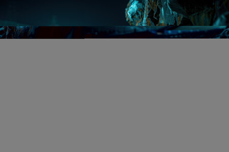 This captivating image captures the essence of nocturnal urban landscapes, with an illuminated stadium standing majestically against a backdrop of towering rock cliffs The vibrant lights of the stadium contrast with the rugged darkness of the cliffs, creating a mesmerizing interplay of light and shadow This photo is a testament to the beauty and architectural ingenuity of modern cities, where man-made structures coexist harmoniously with natural wonders AI Generativeの素材