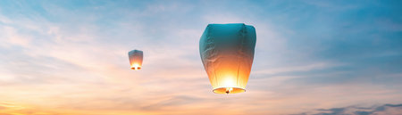 Witness a breathtaking twilight scene: sky lanterns ascend, embodying hope and freedom Soft sunset hues paint a serene backdrop for the moving spectacle Two lanterns drift gracefully, evoking love and celebration A memorable, emotional visual of affection and expression in a peaceful, wondrous moment AI Generativeの素材