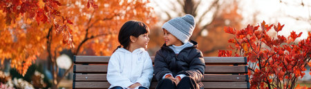 Two children, bundled in jackets, sit side-by-side on a wooden bench amidst vibrant fall leaves One wears a light top, the other a dark jacket and gray hat Their close proximity captures a heartwarming moment of friendship and connection, set against the backdrop of autumnal beauty AI Generativeの素材