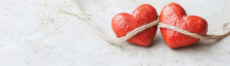 Download this free, high-resolution Valentine's Day card Two intertwined red hearts, tied with twine, rest on a subtly textured background Perfect for printing, personalizing, or sharing online This elegant, romantic design, licensed under CC0, symbolizes enduring love and is ideal for personal or commercial use AI Generativeの素材