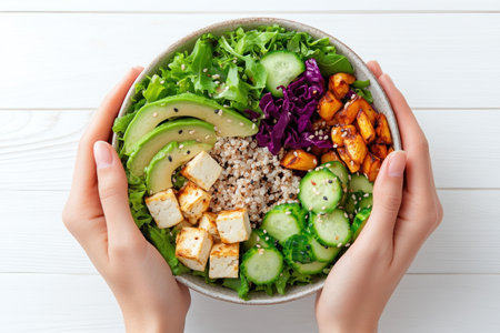 A woman enjoys a vibrant vegan salad with baked vegetables The top-down shot showcases an artfully arranged Buddha bowl featuring avocado, tofu, and buckwheat This culinary masterpiece promotes healthy living by offering a symphony of nourishing textures and tastes for both body and soul It's a delightful, nutritious meal perfect AI Generativeの素材