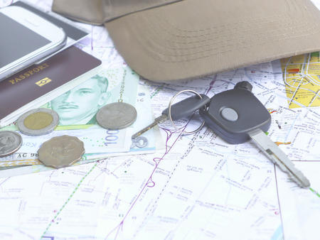 Key car with mobile phone and passport on map for traveling necessary things conceptの写真素材