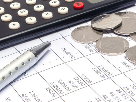 Calculator and pen over financial accounting document