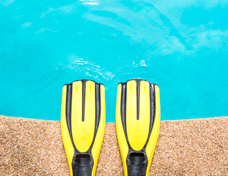 Pair of yellow fins by swimming poolの写真素材
