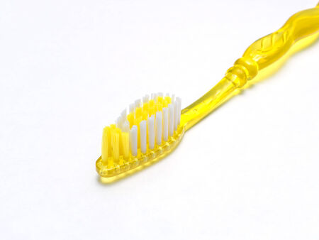 Close up yellow toothbrush on white backgroundの写真素材