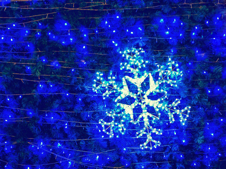 Close up light bulb snowflake shape on Christmas treeの写真素材