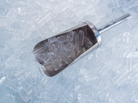 close up ice cubes and stainless ice scoopの写真素材