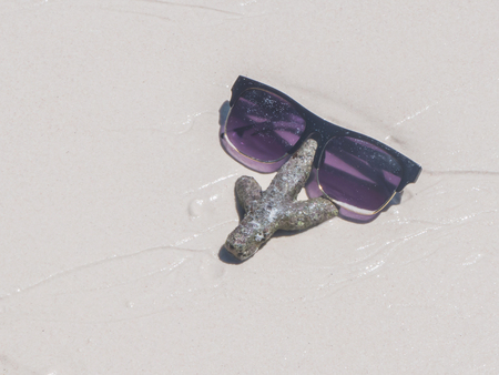 Sunglasses and coral on the summer sandy beachの写真素材