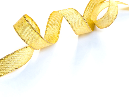 Close up curved gold satin ribbon over white backgroundの写真素材