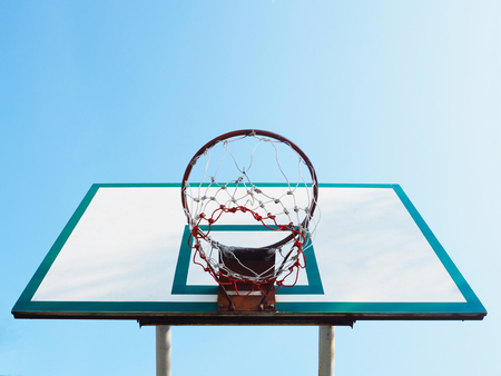 look up to basketball hoop cage over clear blue sky background