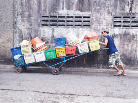 PHUKET, THAILAND - MAY 04, 2016: An unidentified man pushes barrow with many fruit baskets at the old town market  on May 04, 2016 in Phuket province, Thailand.のeditorial素材