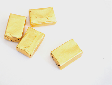 Toffee and gold wrapper packaging on white backgroundの写真素材