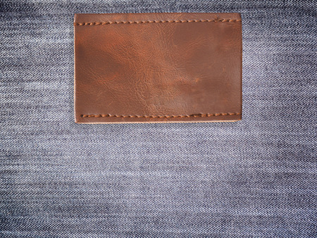Close up blank brown leather jean label over denim backgroundの写真素材