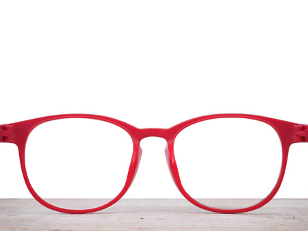 Close up red glasses lenses on wooden table isolated on white background