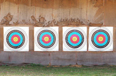 Row of four archery target rings on old brown fabric background.の写真素材