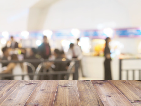 Perspective wood and blurred food court with crowd people. product display template.の写真素材