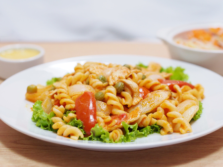 Close up cooked macaroni with tomato sauce on white plate の写真素材
