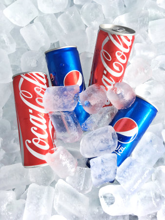 BANGKOK , THAILAND - AUGUST 31, 2017: Coca-Cola and Pepsi slim cans on ice background.