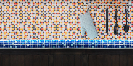 Close up kitchen utensils hanging over colorful mosaic wall tiles with copy space for display the product. Banner and montage style concept.の写真素材