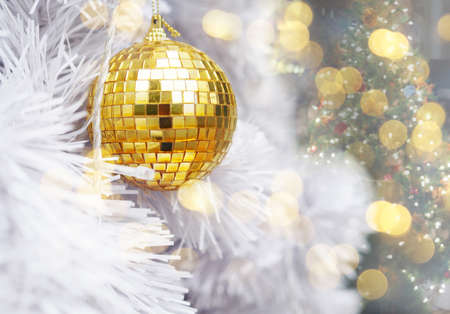 Winter holidays and christmas background concept. Close up golden glitter balls on white fir pine tree with copy space.の写真素材
