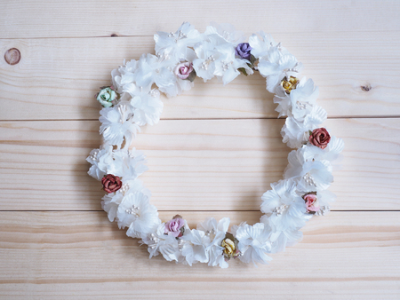 Wreath of white flower with small rose on wood background. Circle floral frame for wedding decoration.の写真素材
