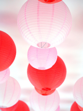 Group of red and pink paper lanterns hanging on ceiling for Valentine and Chinese new year holidays festival decoration.の写真素材