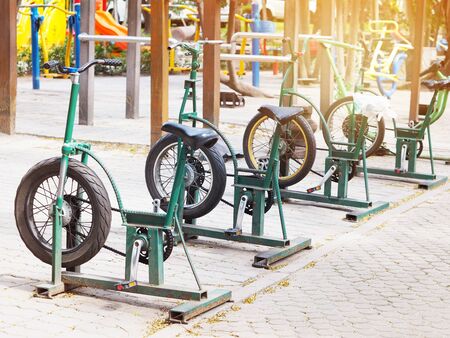 Row of metal outdoor exercise bikes. Equipment for gym at the public park. Healthy lifestyle in Thailand.の写真素材