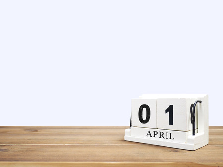 White vintage wood block calendar present date 01 and month April on brown wooden table over grey background with copy space.の写真素材