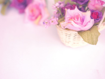 Close up colorful rose bouquet in small basket on white background for wedding or valentine card. Pastel color vintage filter effect.の写真素材