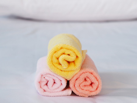 Close up colorful towels on bed in bedroom.の写真素材