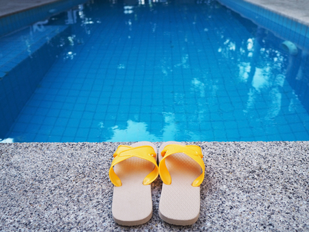 Yellow sandal by swimming pool. Summer holiday background concept.の写真素材