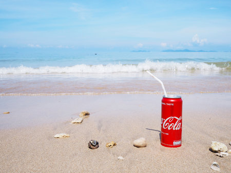 Krabi, Thailand - May 24, 2019: Coca-Cola can soft drink on sand at summer beach background.のeditorial素材