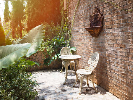 Outdoor summer garden decoration with vintage chairs and table furniture.の写真素材