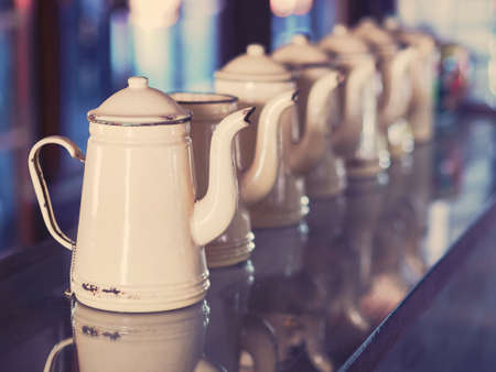 Close up cream vintage rustic teapot set on glass table.の写真素材